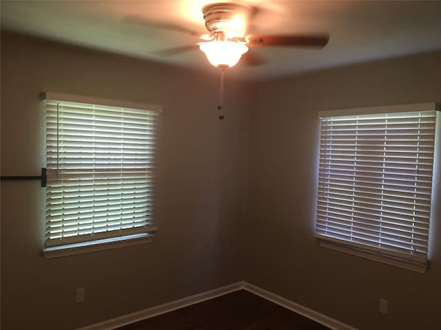 unfurnished room featuring ceiling fan, baseboards, and wood finished floors