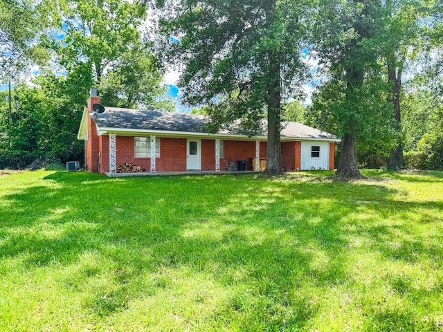 1085 Duke Rd, Kennard, TX 75847 - ranch-style house featuring a front yard, central AC, brick siding, and a chimney