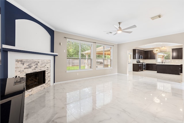 20106 Pinehaven Ln, Spring, TX 77379 - unfurnished living room featuring crown molding, ceiling fan, light marble finish flooring, a stone fireplace, and arched walkways