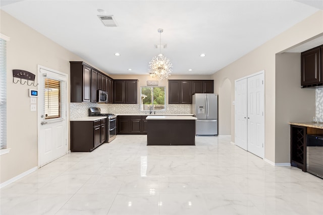 20106 Pinehaven Ln, Spring, TX 77379 - kitchen featuring stainless steel appliances, light countertops, backsplash, dark brown cabinetry, and light marble finish floors