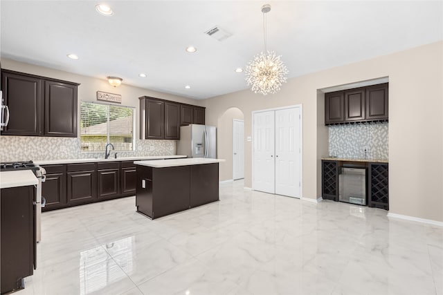 20106 Pinehaven Ln, Spring, TX 77379 - kitchen featuring refrigerator with ice dispenser, light marble finish flooring, light countertops, arched walkways, and recessed lighting