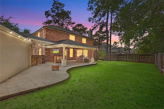 20106 Pinehaven Ln, Spring, TX 77379 - back of property at dusk with brick siding, a chimney, and a patio area