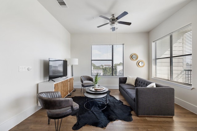 living room with a ceiling fan, baseboards, and wood finished floors
