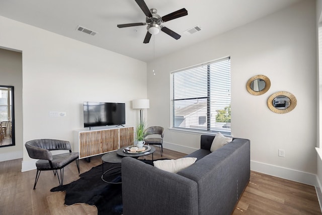 living room featuring a ceiling fan, wood finished floors, and baseboards