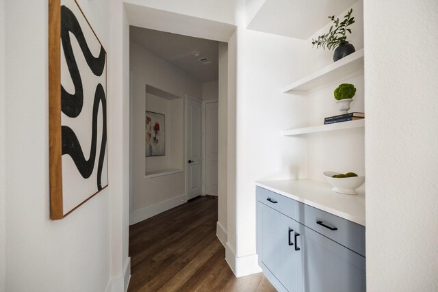 hallway with dark wood-style flooring and baseboards