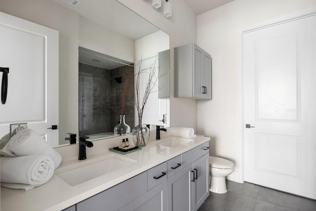 full bathroom featuring toilet, tile patterned floors, tiled shower, and double vanity