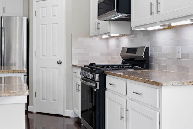12506 Emerald Springs Dr, Pearland, TX 77584 - kitchen with appliances with stainless steel finishes, white cabinets, light stone counters, and tasteful backsplash