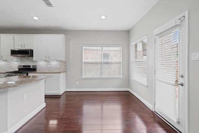 12506 Emerald Springs Dr, Pearland, TX 77584 - kitchen featuring appliances with stainless steel finishes, white cabinets, dark wood-style flooring, light stone counters, and backsplash