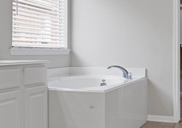 12506 Emerald Springs Dr, Pearland, TX 77584 - bathroom featuring tile patterned flooring, a garden tub, and baseboards