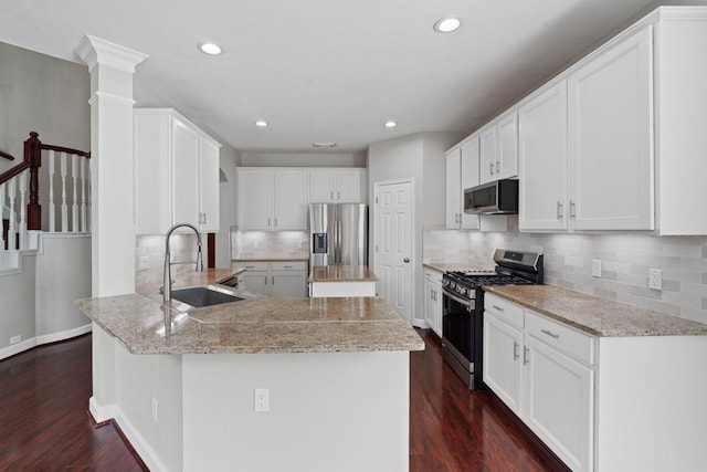 12506 Emerald Springs Dr, Pearland, TX 77584 - kitchen featuring stainless steel appliances, a sink, a peninsula, dark wood finished floors, and recessed lighting