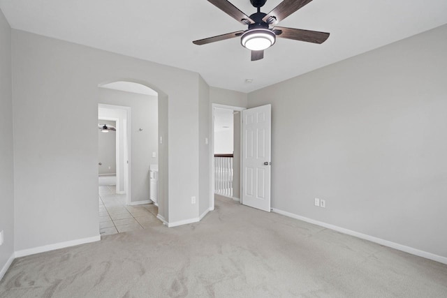 12506 Emerald Springs Dr, Pearland, TX 77584 - unfurnished bedroom featuring arched walkways, carpet flooring, baseboards, and ceiling fan
