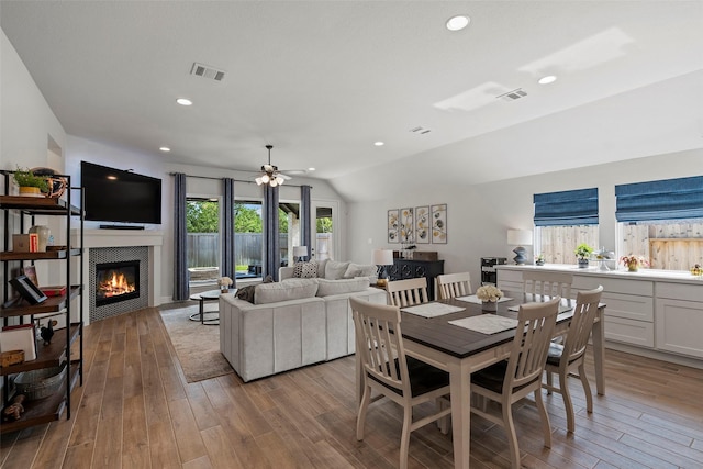 19322 Stagecoach Breeze Ln, Tomball, TX 77377 - dining area with wood finished floors, a fireplace, ceiling fan, vaulted ceiling, and recessed lighting