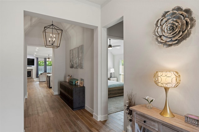19322 Stagecoach Breeze Ln, Tomball, TX 77377 - hallway with a chandelier, dark wood-style floors, and baseboards