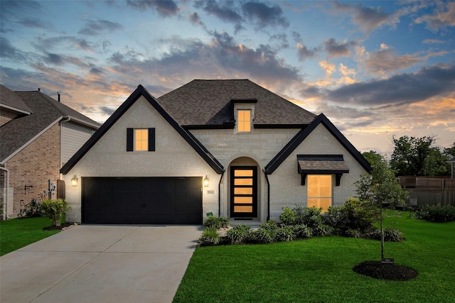 19322 Stagecoach Breeze Ln, Tomball, TX 77377 - french country inspired facade featuring concrete driveway, a yard, stone siding, a shingled roof, and an attached garage