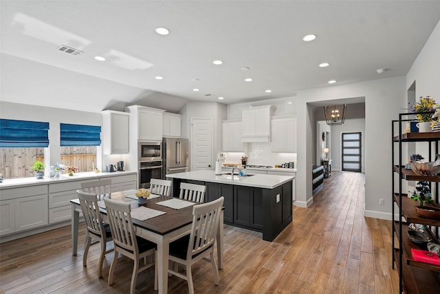 19322 Stagecoach Breeze Ln, Tomball, TX 77377 - kitchen with stainless steel appliances, a kitchen island with sink, light wood-type flooring, light countertops, and recessed lighting