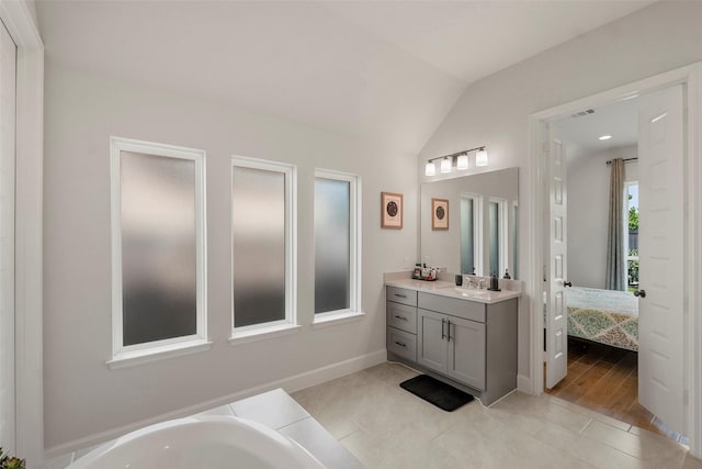 19322 Stagecoach Breeze Ln, Tomball, TX 77377 - bathroom featuring vaulted ceiling, vanity, ensuite bath, tile patterned flooring, and a bath