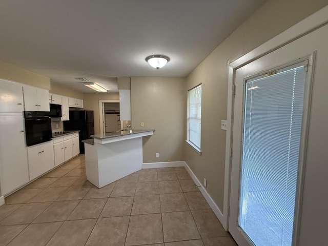 10331 Collingswood Rd, La Porte, TX 77571 - kitchen featuring black appliances, light tile patterned floors, a peninsula, white cabinets, and baseboards