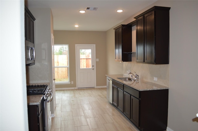 3230 Harmony Creek Ln, Spring, TX 77386 - kitchen featuring appliances with stainless steel finishes, a sink, decorative backsplash, dark brown cabinets, and recessed lighting