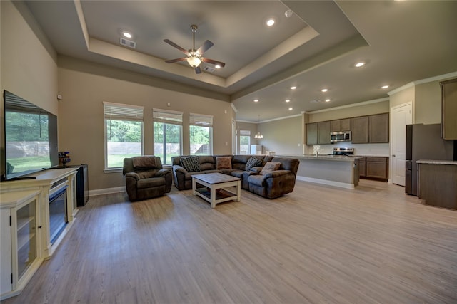 26495 Pin Oak Dr, Hempstead, TX 77445 - living area with a ceiling fan, a tray ceiling, light wood-style flooring, recessed lighting, and baseboards