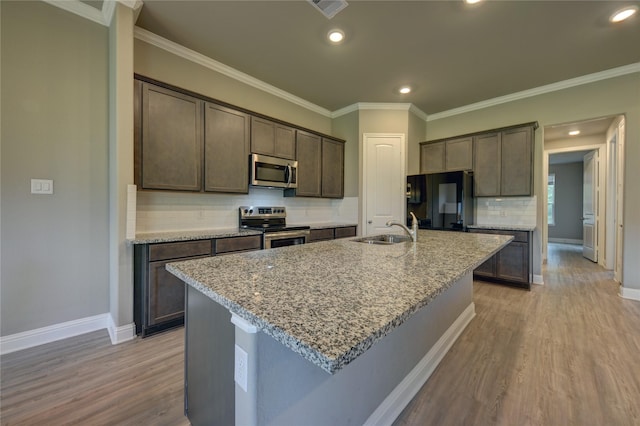 26495 Pin Oak Dr, Hempstead, TX 77445 - kitchen featuring stainless steel appliances, a sink, wood finished floors, dark brown cabinets, and crown molding