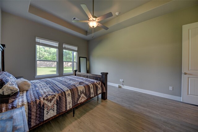 26495 Pin Oak Dr, Hempstead, TX 77445 - bedroom featuring wood finished floors, baseboards, a raised ceiling, and ceiling fan