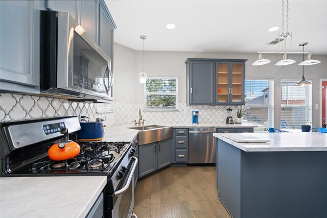 2505 Cypress Springs Ct, Pearland, TX 77584 - kitchen with stainless steel appliances, a sink, dark wood-style floors, decorative backsplash, and glass insert cabinets