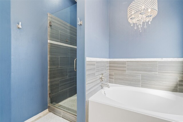 2505 Cypress Springs Ct, Pearland, TX 77584 - bathroom with a garden tub, a shower stall, baseboards, and a chandelier