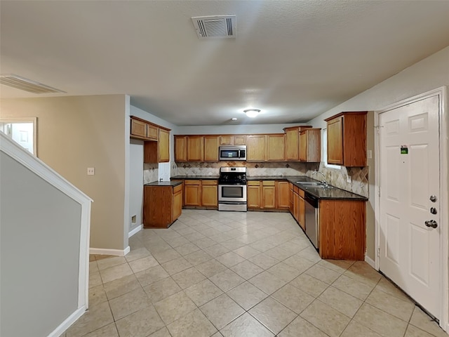 18481 Sunrise Oaks Ct, Montgomery, TX 77316 - kitchen with appliances with stainless steel finishes, dark countertops, decorative backsplash, and a sink