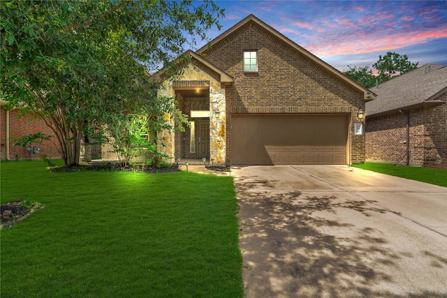 traditional-style home featuring concrete driveway, brick siding, a lawn, and a garage