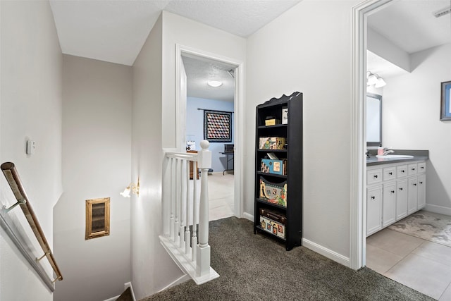 16107 York Minster Dr, Spring, TX 77379 - hall featuring an upstairs landing, a sink, carpet flooring, baseboards, and a textured ceiling