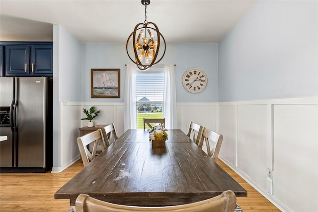 4114 Courageous Ln, Galveston, TX 77554 - dining space featuring a chandelier, light wood-style flooring, wainscoting, and a decorative wall