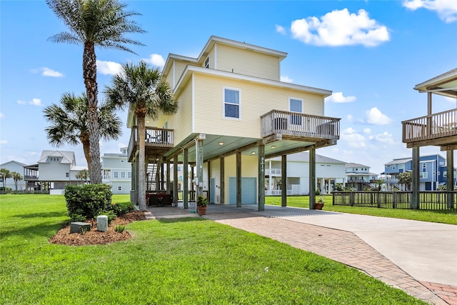 4114 Courageous Ln, Galveston, TX 77554 - back of house featuring a carport, concrete driveway, a residential view, a garage, and a balcony