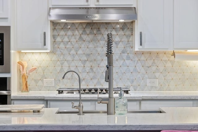 4008 Centre Glen Dr, Houston, TX 77043 - kitchen with white cabinetry, backsplash, ventilation hood, and light stone counters