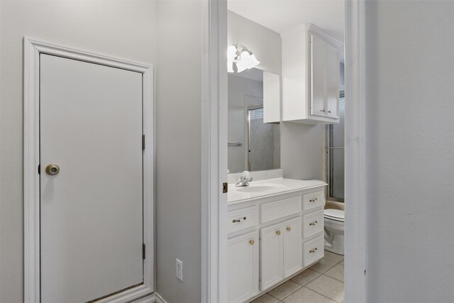 407 W Main St, Brenham, TX 77833 - full bathroom with toilet, tile patterned floors, vanity, and a shower with door