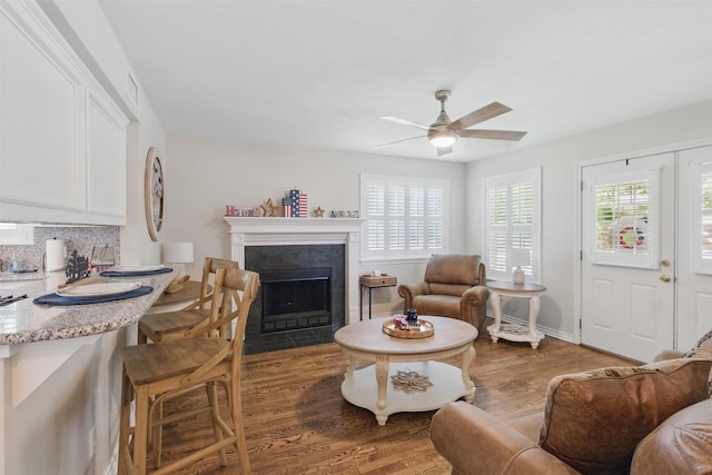 407 W Main St, Brenham, TX 77833 - living area with healthy amount of natural light, a ceiling fan, wood finished floors, and a fireplace with flush hearth