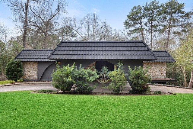 827 Magnolia St, Livingston, TX 77351 - view of front of house featuring stone siding, a front lawn, and mansard roof