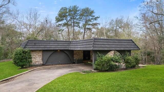 827 Magnolia St, Livingston, TX 77351 - view of front of house with mansard roof, stone siding, a front yard, and concrete driveway
