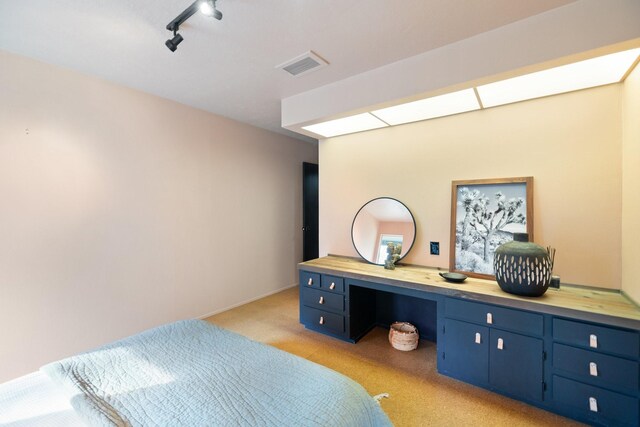 827 Magnolia St, Livingston, TX 77351 - bedroom with light carpet, track lighting, and an office area