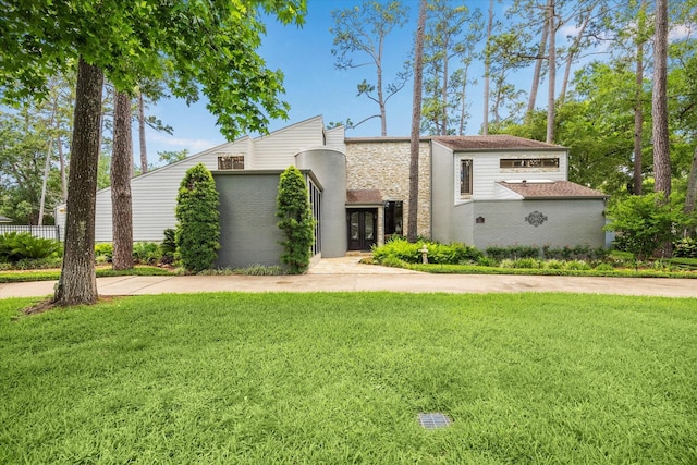 mid-century home featuring a front yard, french doors, and brick siding