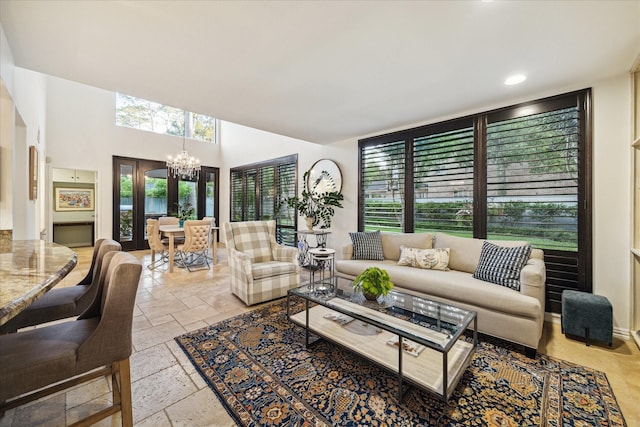 living area featuring stone tile floors, a chandelier, and recessed lighting