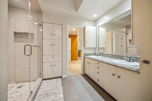 bathroom with a stall shower, double vanity, and recessed lighting