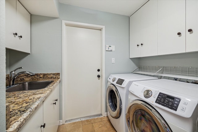 laundry room featuring separate washer and dryer, cabinet space, and light stone finish flooring