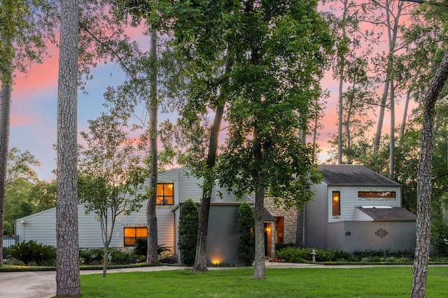 view of front facade with a lawn and brick siding
