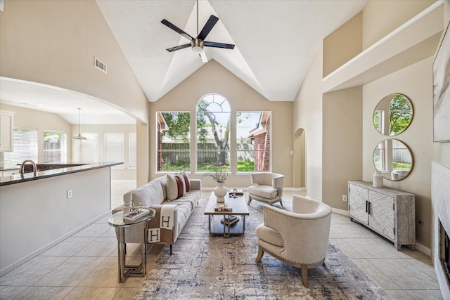 17426 Little Riata Dr, Houston, TX 77095 - living area with a ceiling fan, light tile patterned floors, high vaulted ceiling, arched walkways, and baseboards