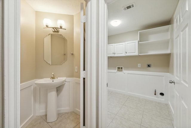 17426 Little Riata Dr, Houston, TX 77095 - bathroom featuring tile patterned floors, wainscoting, and a decorative wall