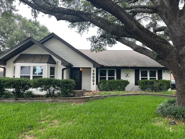 ranch-style home with a front lawn and brick siding