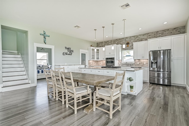16631 Jean Lafitte Rd, Galveston, TX 77554 - dining area featuring light wood finished floors, stairway, and recessed lighting