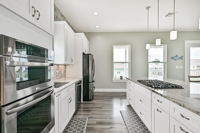 16631 Jean Lafitte Rd, Galveston, TX 77554 - kitchen with appliances with stainless steel finishes, healthy amount of natural light, white cabinets, light stone countertops, and recessed lighting