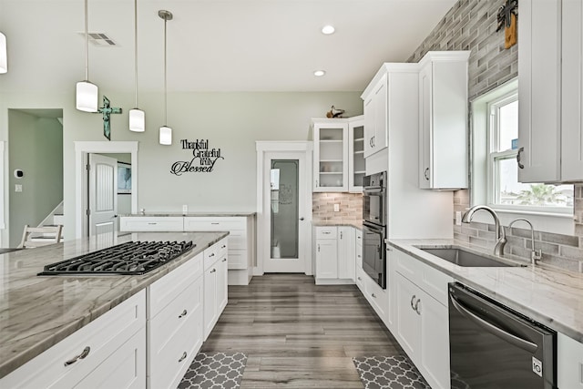 16631 Jean Lafitte Rd, Galveston, TX 77554 - kitchen with black appliances, a sink, white cabinetry, light stone counters, and recessed lighting