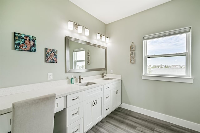 16631 Jean Lafitte Rd, Galveston, TX 77554 - bathroom with baseboards, healthy amount of natural light, wood finished floors, and double vanity